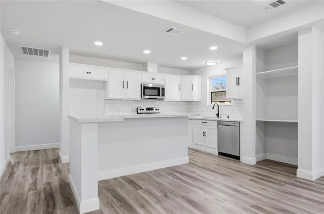 a kitchen with white cabinets and white appliances