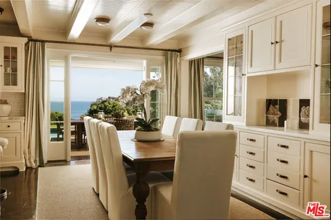 a dining room with furniture and a large window