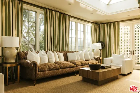 a living room with furniture and large windows