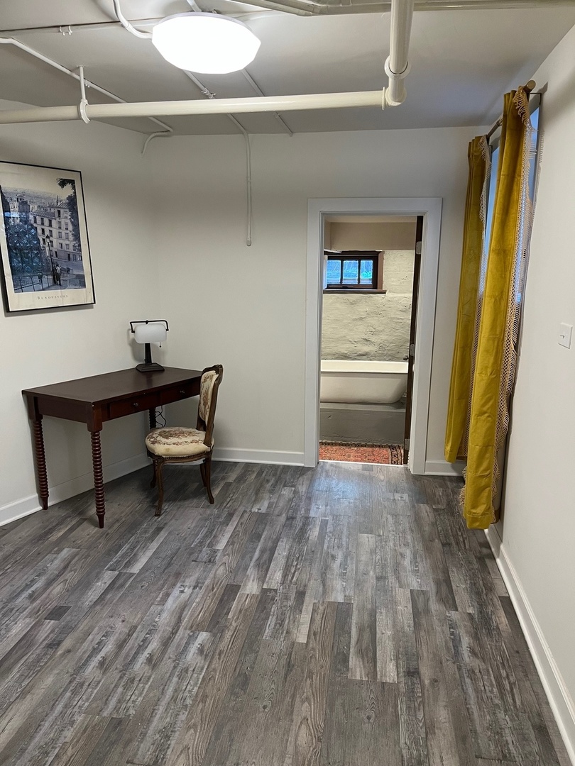 622 West Briar Place, Unit G Chicago, IL 60657 - Photo 12 of 16 a view of a bedroom with wooden floor wooden cabinet and windows