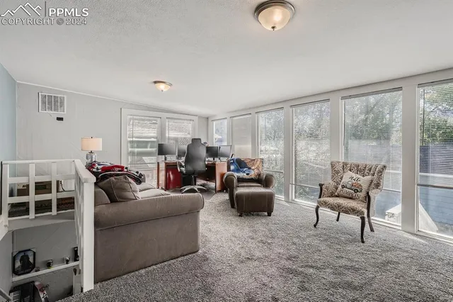 a living room with furniture and a floor to ceiling window
