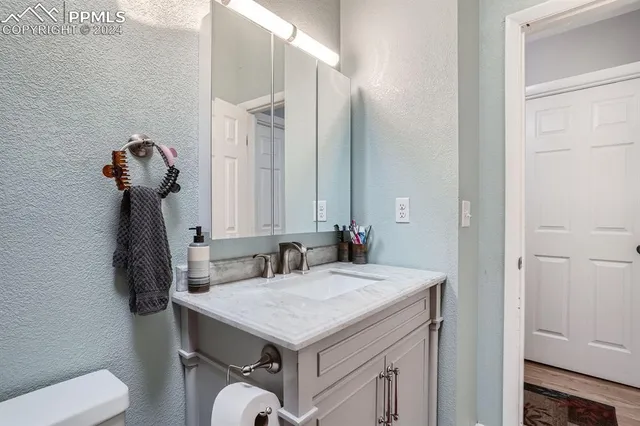 a bathroom with a sink a toilet and a mirror