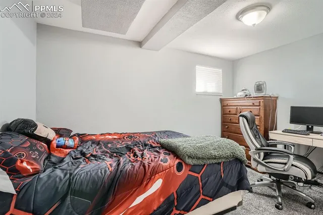a bedroom with a bed and a computer on a desk