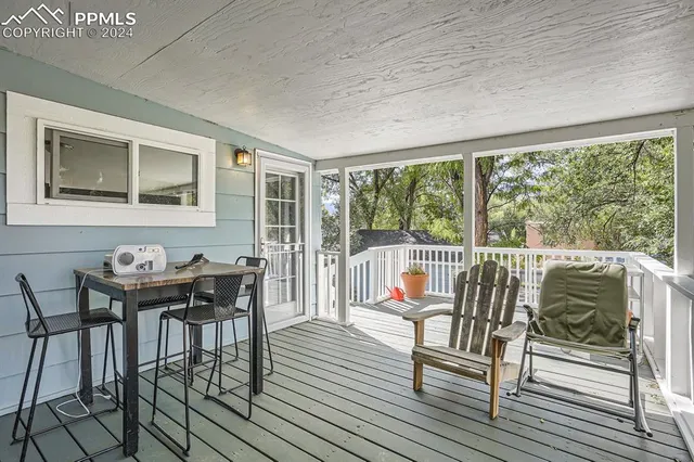 a balcony with wooden floor and outdoor seating