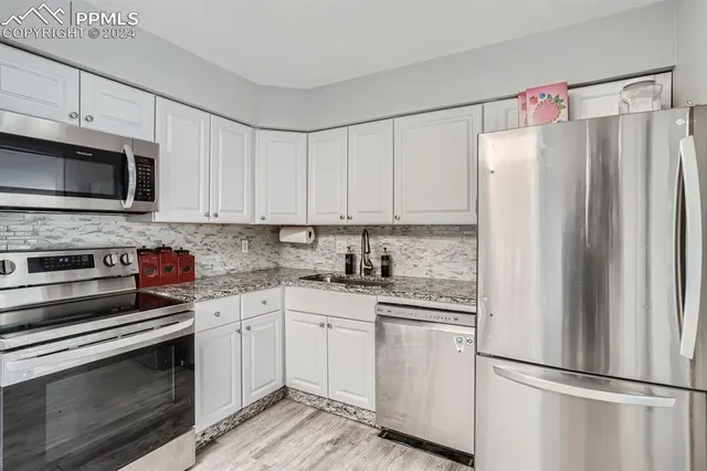 a kitchen with cabinets stainless steel appliances and white cabinets