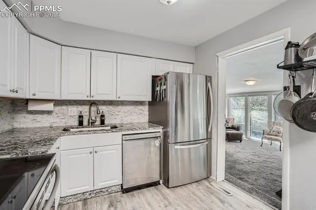 a kitchen with white cabinets and stainless steel appliances
