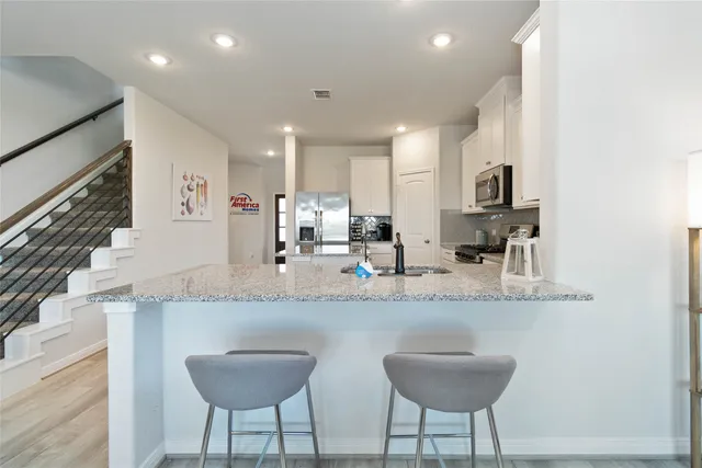 a kitchen with stainless steel appliances granite countertop a sink and a refrigerator