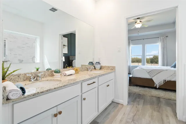 a bathroom with a granite countertop sink double and mirror