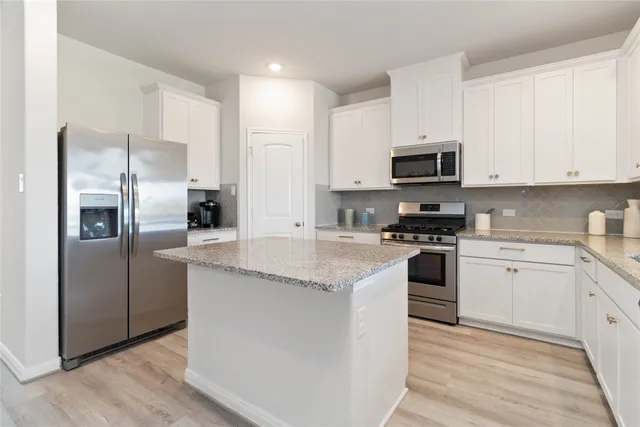 a kitchen with granite countertop a sink and cabinets