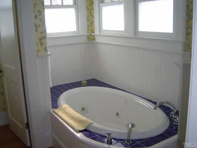 2106 Cowper Drive Raleigh, NC 27608 - Photo 12 of 12 a bath tub sitting in a bathroom next to a window