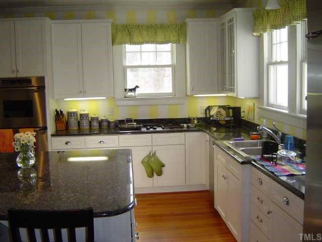 2106 Cowper Drive Raleigh, NC 27608 - Photo 3 of 12 a kitchen with stainless steel appliances granite countertop a stove a sink and a microwave
