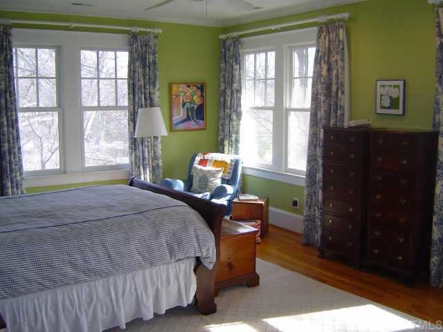 2106 Cowper Drive Raleigh, NC 27608 - Photo 10 of 12 a bedroom with a bed and wooden floor