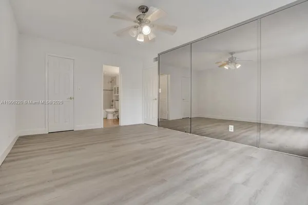 wooden floor in an empty room with a fan