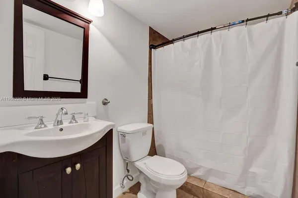 a bathroom with a sink vanity mirror and toilet