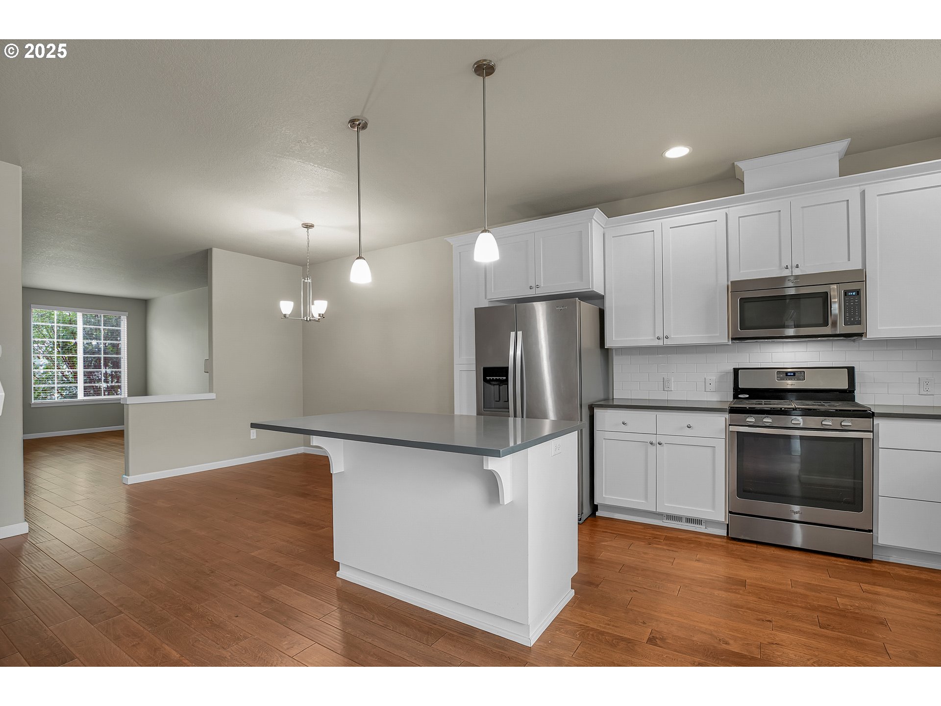 18370 Southwest Anna Mae Lane Beaverton, OR 97003 - Photo 12 of 29 a kitchen with stainless steel appliances granite countertop a refrigerator a sink a stove and oven with wooden floor