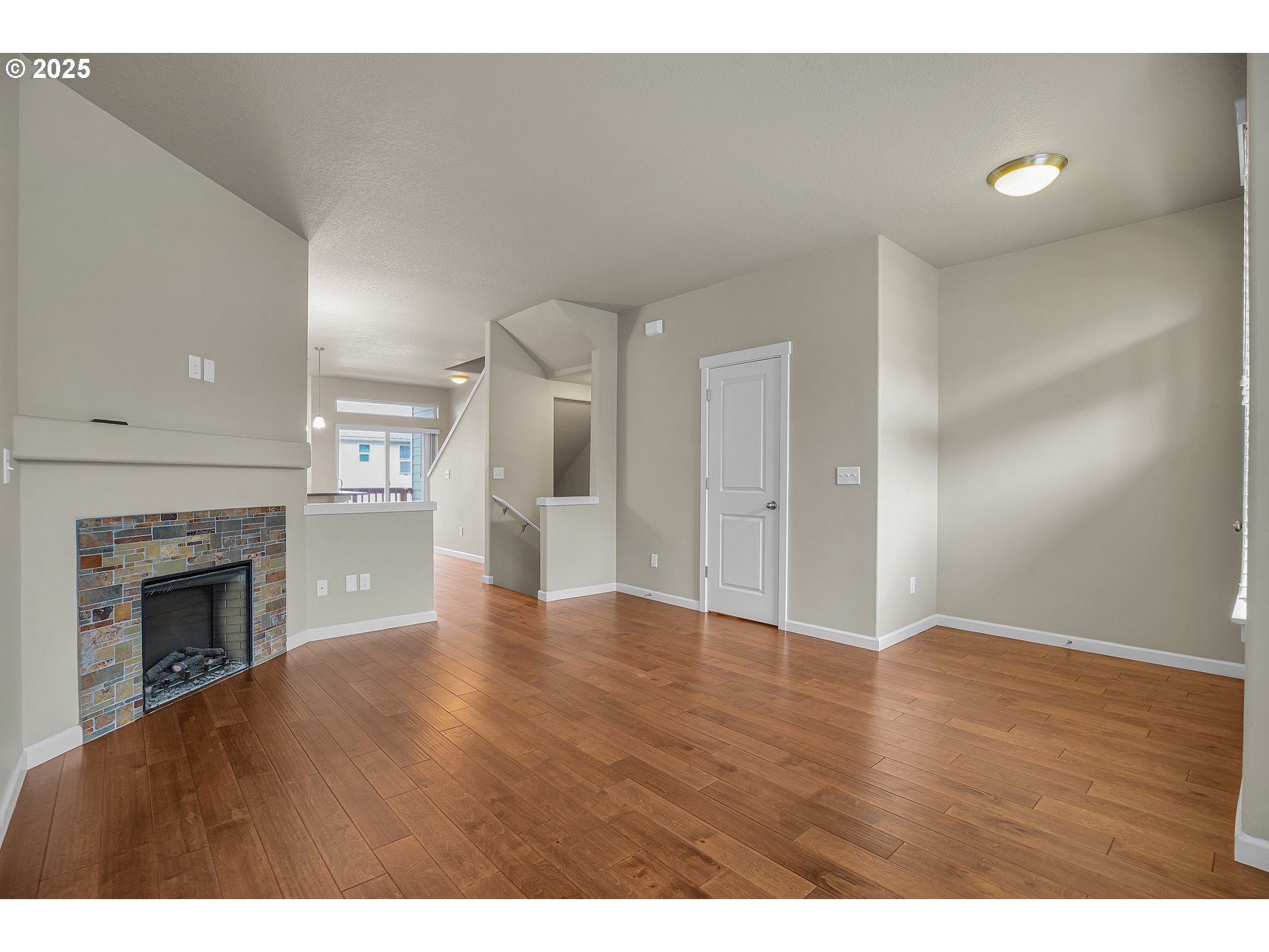 18370 Southwest Anna Mae Lane Beaverton, OR 97003 - Photo 5 of 29 a view of an empty room with wooden floor fireplace and a window