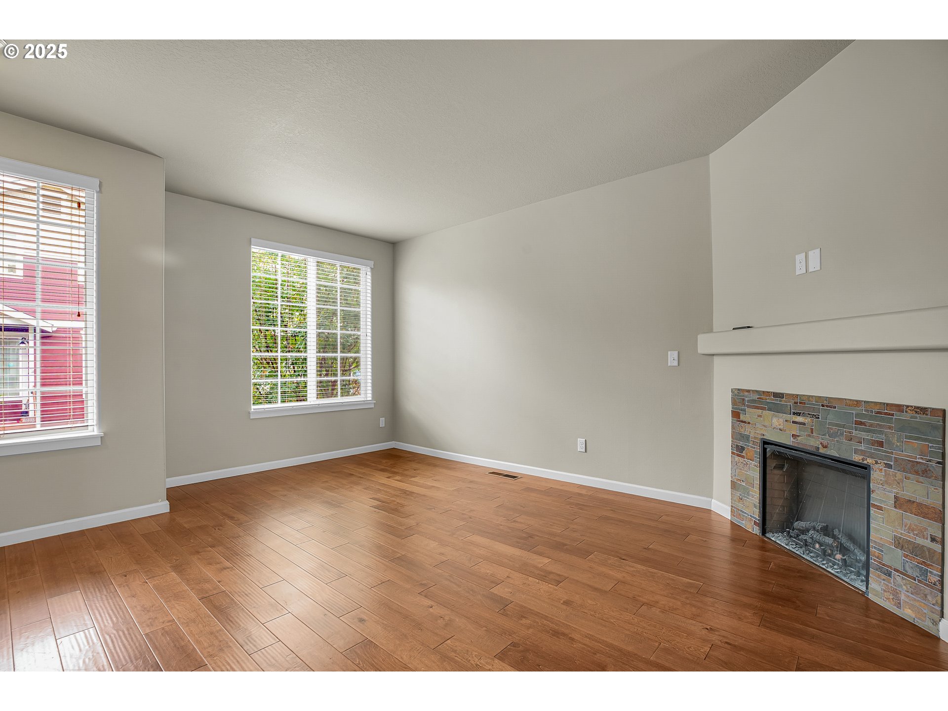 18370 Southwest Anna Mae Lane Beaverton, OR 97003 - Photo 7 of 29 an empty room with wooden floor fireplace and windows