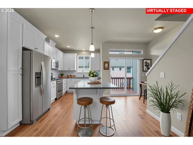 a open kitchen with kitchen island a refrigerator a stove a sink a dining table and chairs