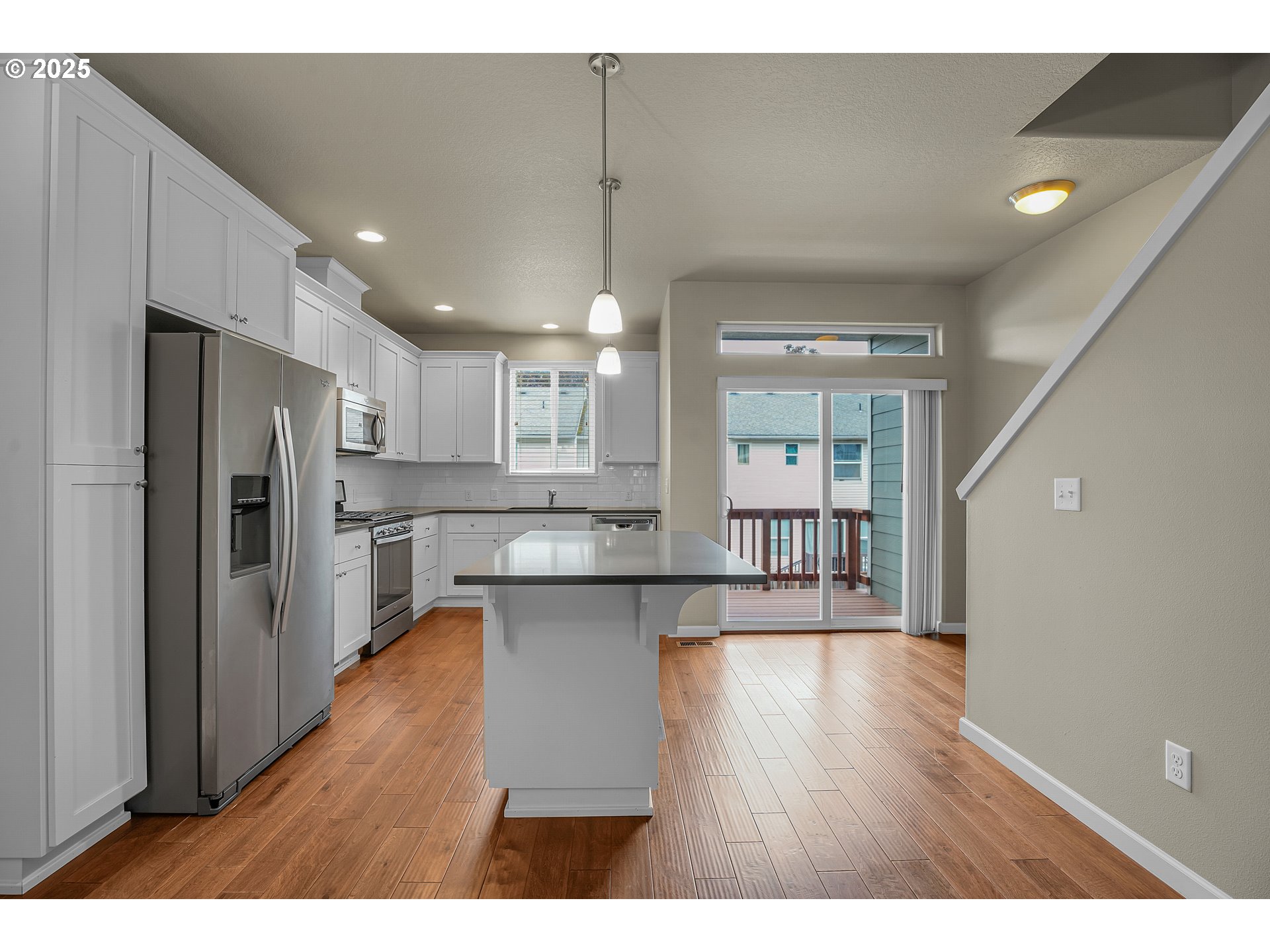 18370 Southwest Anna Mae Lane Beaverton, OR 97003 - Photo 9 of 29 a open kitchen with kitchen island wooden floors appliances and center island