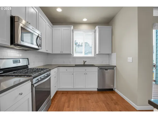 a kitchen with stainless steel appliances granite countertop a sink a stove a microwave and cabinets