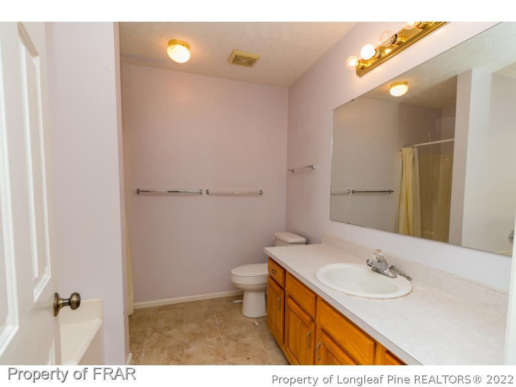 1941-3 Sardonyx Road Fayetteville, NC 28303 - Photo 15 of 27 a bathroom with a sink a toilet and a mirror