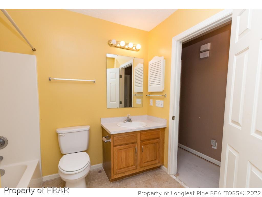 1941-3 Sardonyx Road Fayetteville, NC 28303 - Photo 22 of 27 a bathroom with a granite countertop toilet sink and mirror