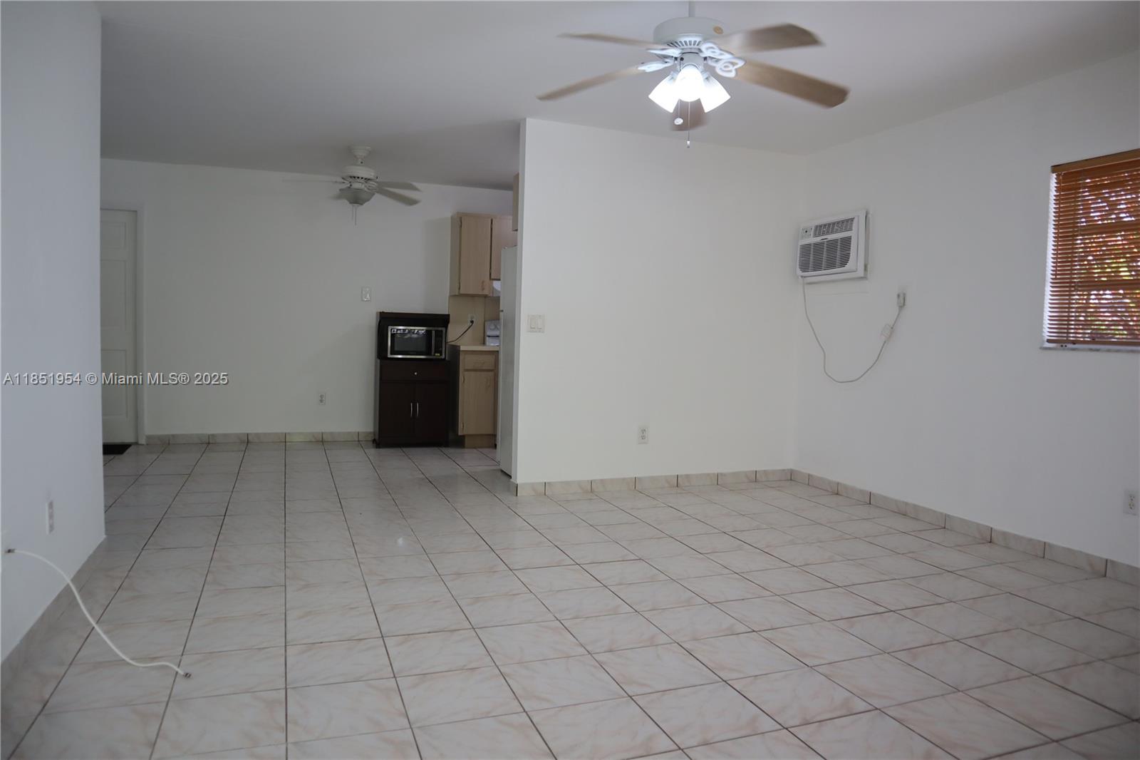 18531 Southwest 268th Street, Unit 18531 Homestead, FL 33031 - Photo 11 of 18 a view of a livingroom with a chandelier fan and windows