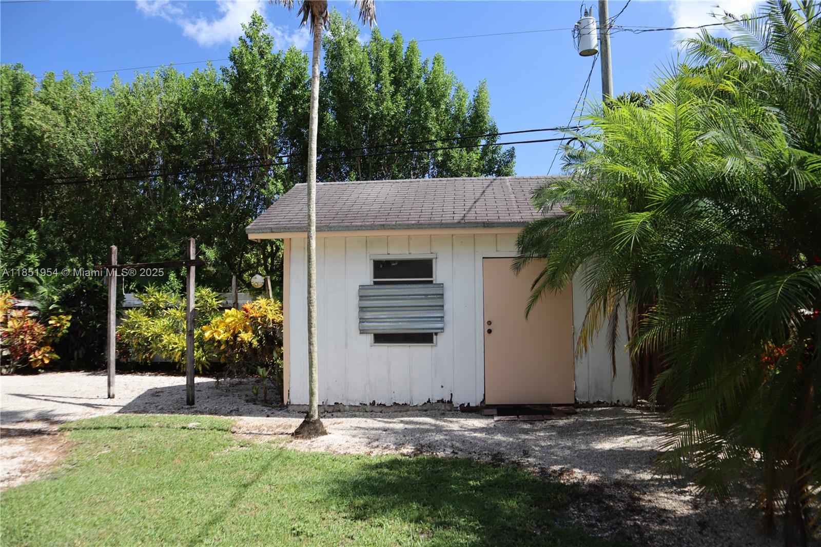 18531 Southwest 268th Street, Unit 18531 Homestead, FL 33031 - Photo 6 of 18 a backyard of a house with potted plants and large tree