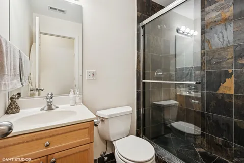 a bathroom with a sink a toilet and shower