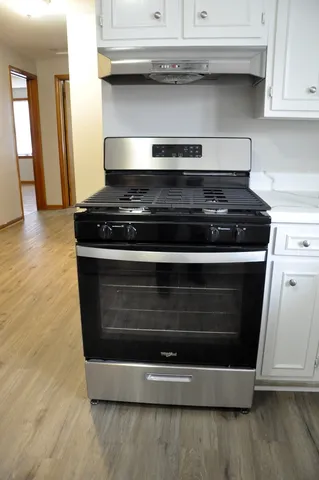 a stove top oven sitting inside of a kitchen