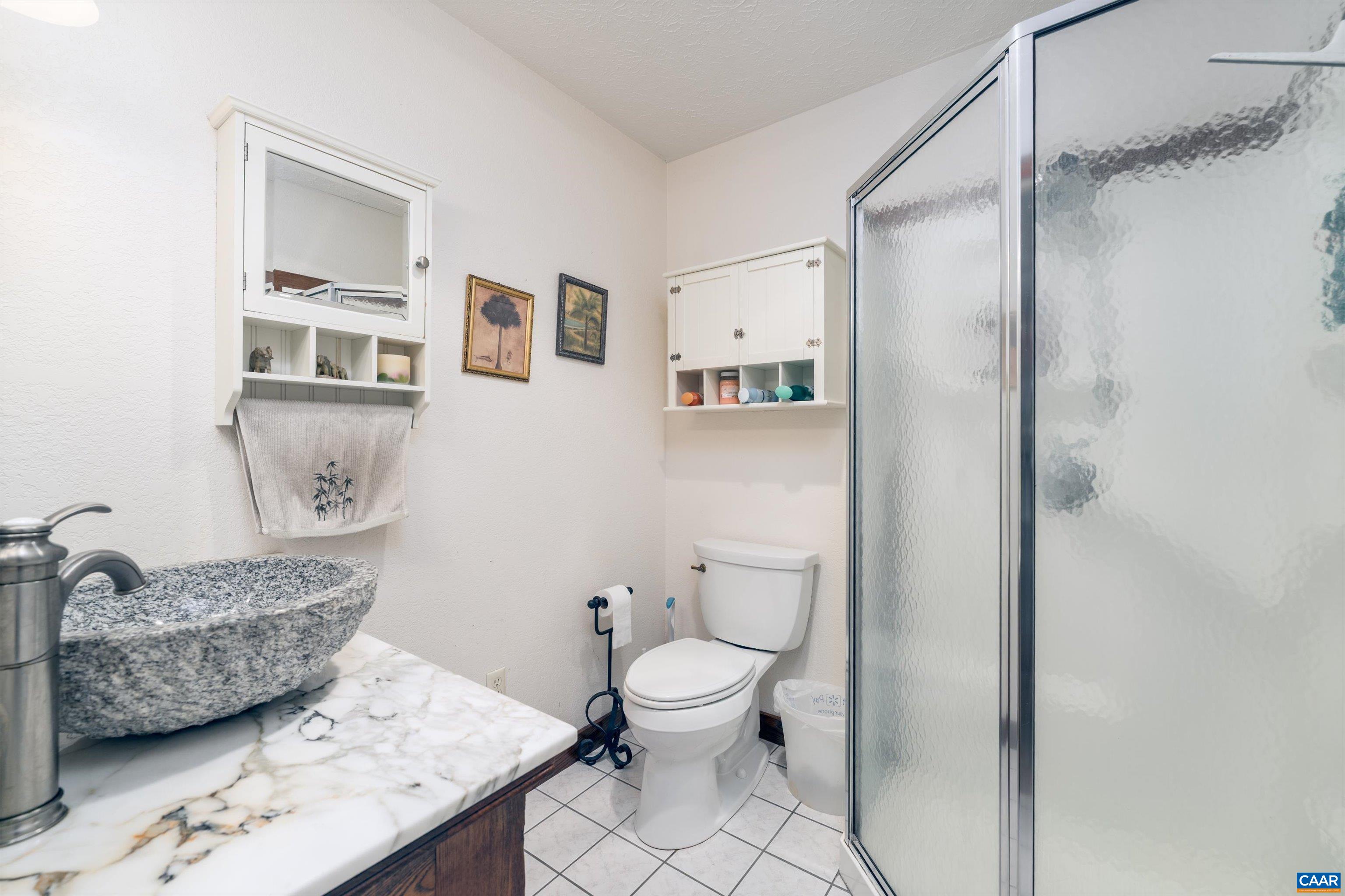 15365 Madison Run Road Gordonsville, VA 22942 - Photo 20 of 38 a bathroom with a granite countertop sink a toilet and a mirror