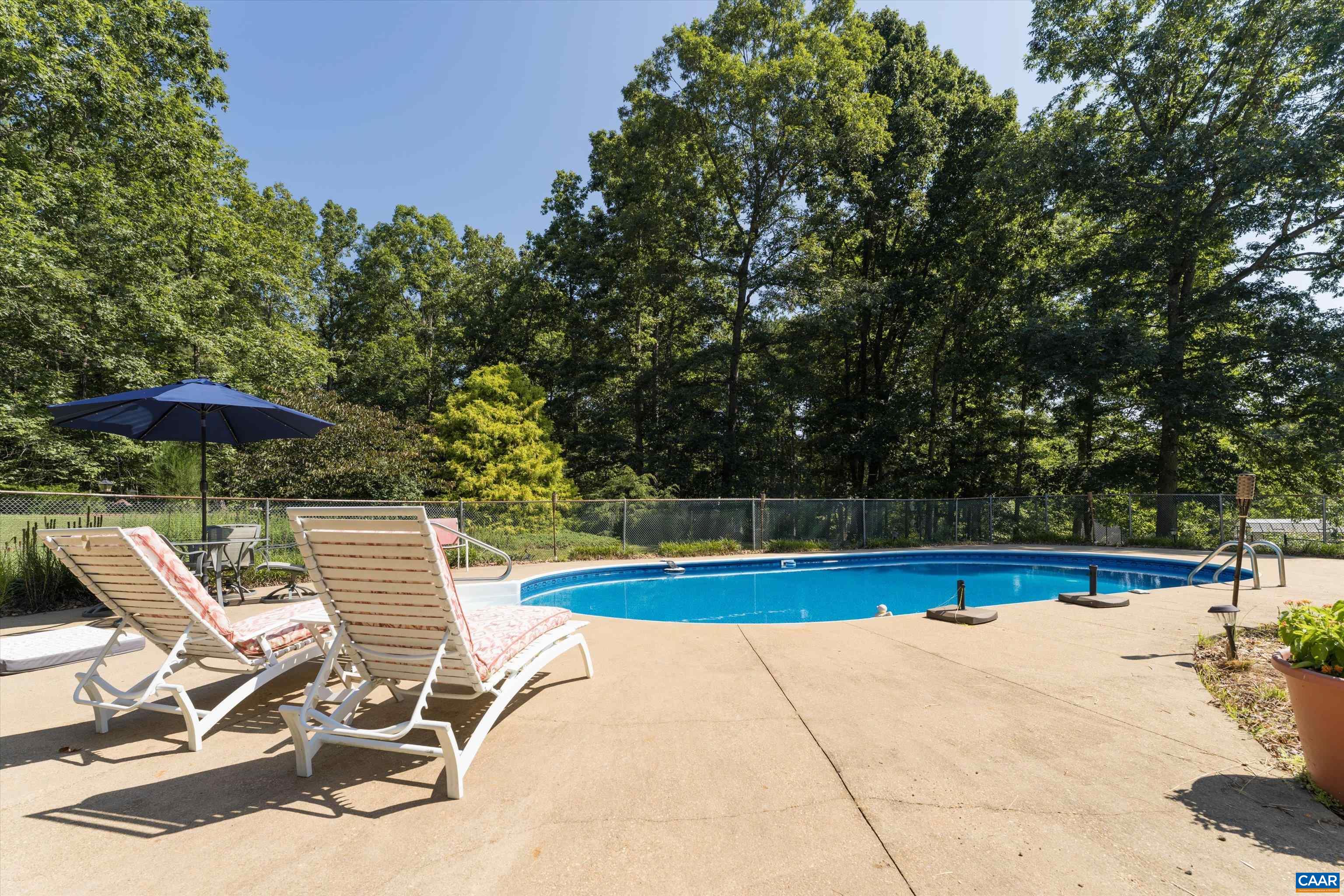 15365 Madison Run Road Gordonsville, VA 22942 - Photo 29 of 38 a view of a swimming pool with a chair and tables in the background