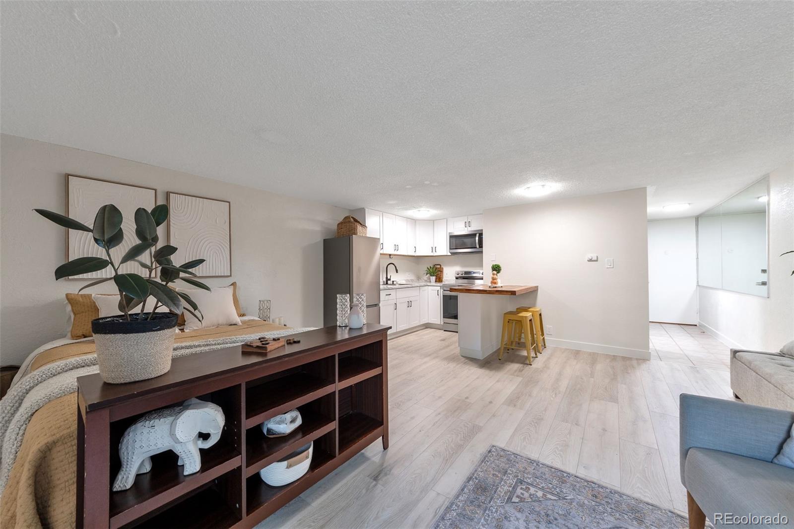 2500 South York Street, Unit 107 Denver, CO 80210 - Photo 4 of 21 a kitchen with stainless steel appliances kitchen island a stove and a sink