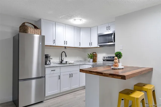 a kitchen with stainless steel appliances granite countertop a refrigerator sink and cabinets
