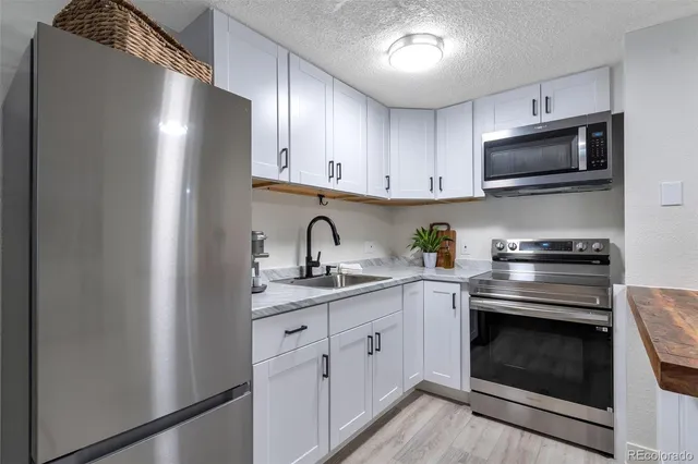 a kitchen with granite countertop cabinets stainless steel appliances and a sink