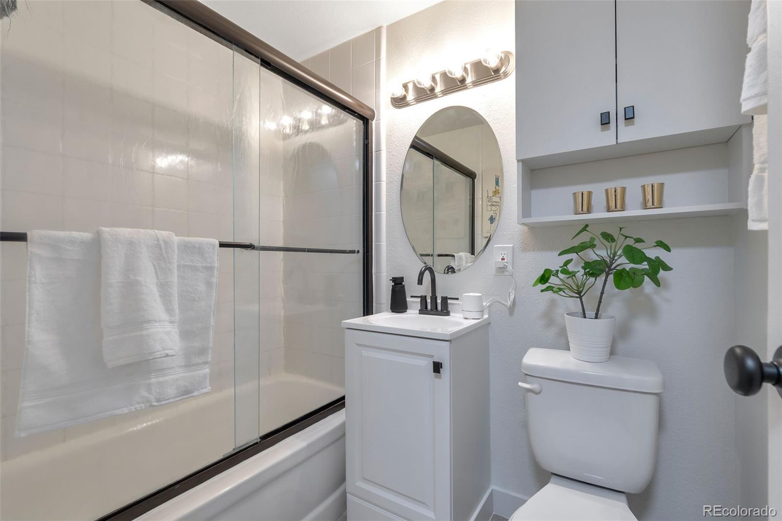 2500 South York Street, Unit 107 Denver, CO 80210 - Photo 9 of 21 a bathroom with a sink a toilet and a mirror
