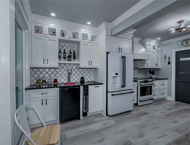 a kitchen with kitchen island a chandelier and living room view