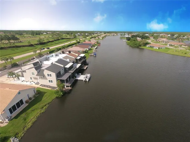 an aerial view of ocean and residential houses with outdoor space