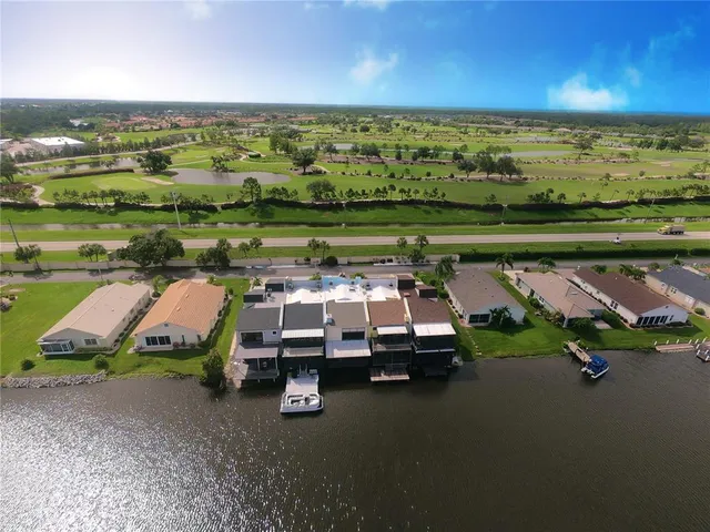 an aerial view of a lake with a car parked in a yard