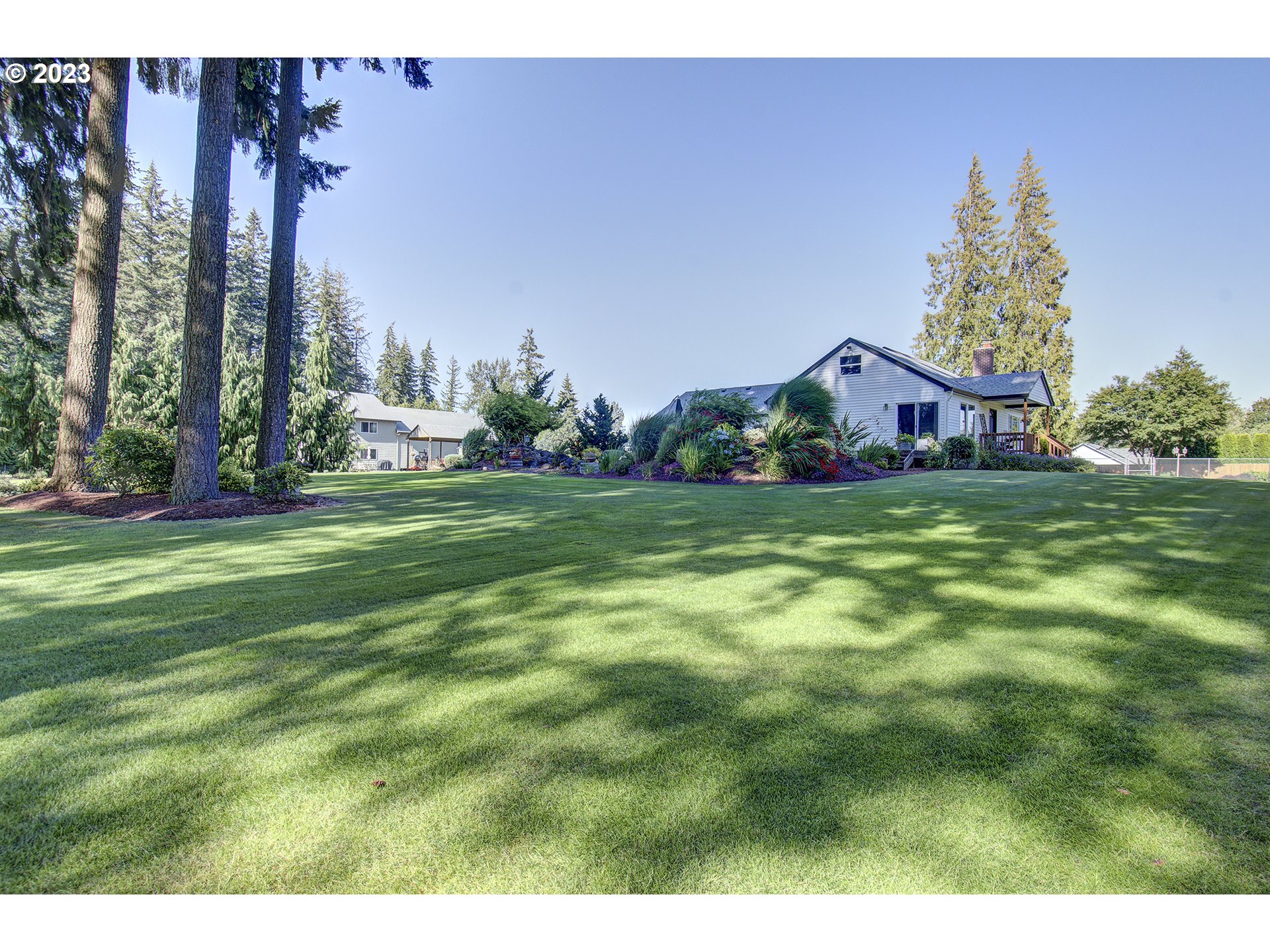 4702 Northeast 199th Street Ridgefield, WA 98642 - Photo 16 of 32 a view of a house with a big yard and large trees