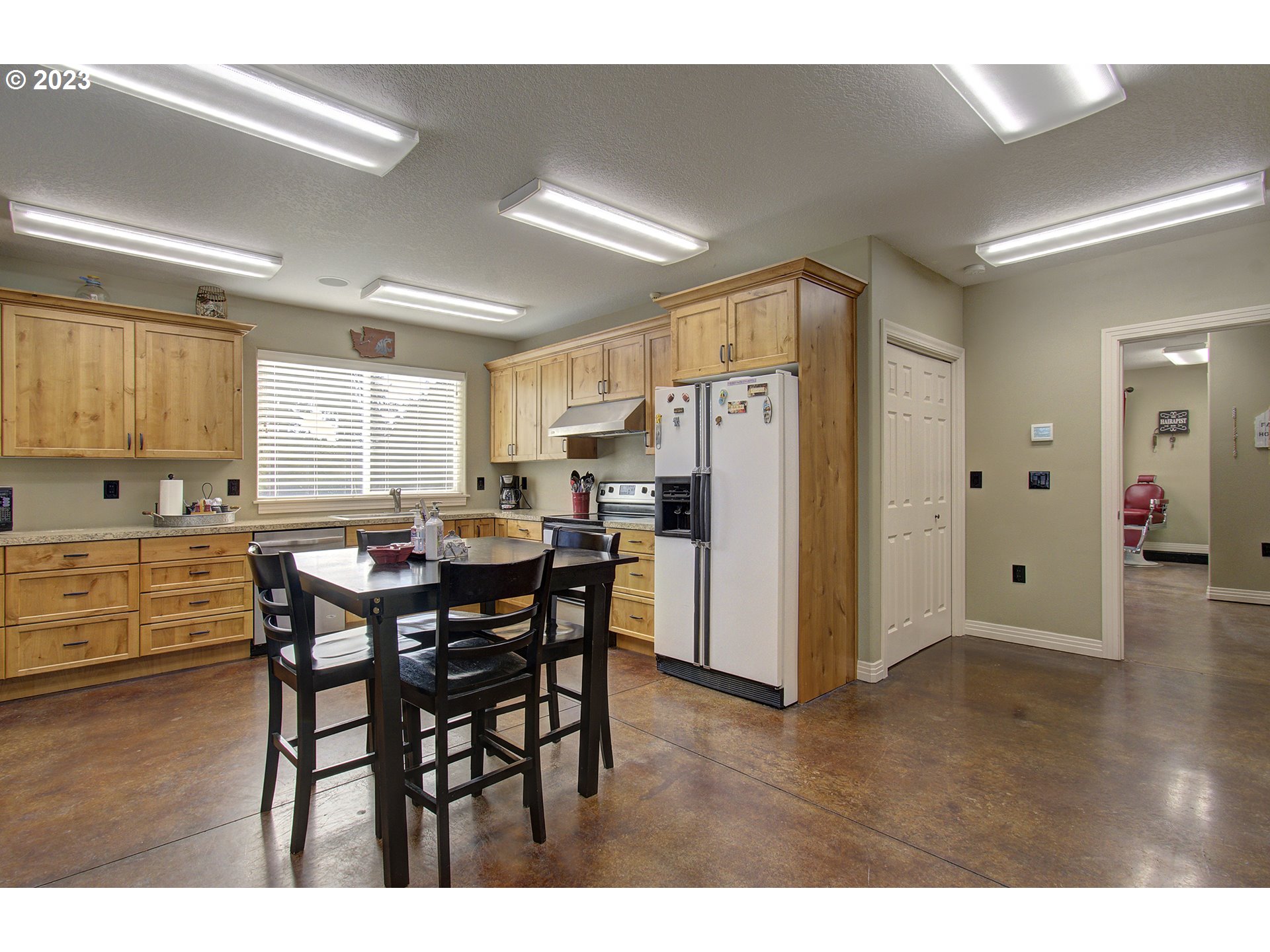 4702 Northeast 199th Street Ridgefield, WA 98642 - Photo 21 of 32 a kitchen with stainless steel appliances a refrigerator a sink dishwasher and a dining table with wooden floor