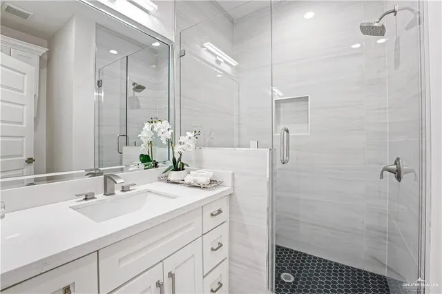 a bathroom with a sink shower and a mirror