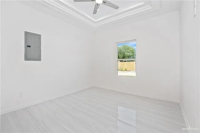 an empty room with a window and a ceiling fan
