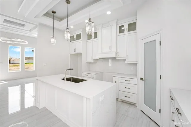 a kitchen that has a lot of white cabinets and stainless steel appliances