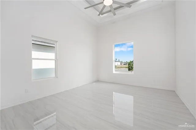 an empty room with a window and a ceiling fan