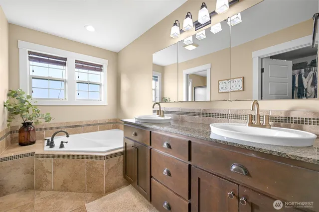 a bathroom with a granite countertop sink mirror and bathtub