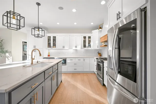 a kitchen with stainless steel appliances a refrigerator sink and cabinets