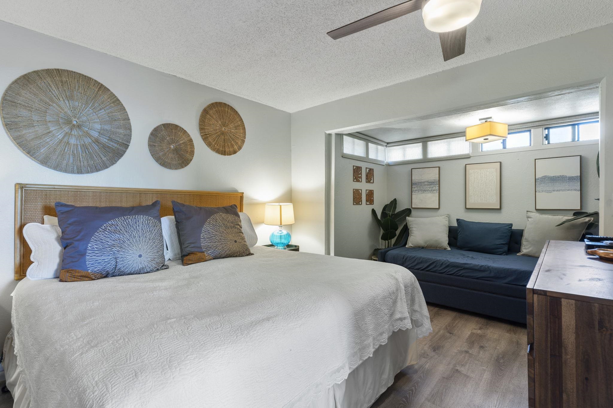 4401 Lower Honoapiilani Road, Unit A101 Lahaina, HI 96761 - Photo 24 of 37 a bedroom with a large bed and a chandelier