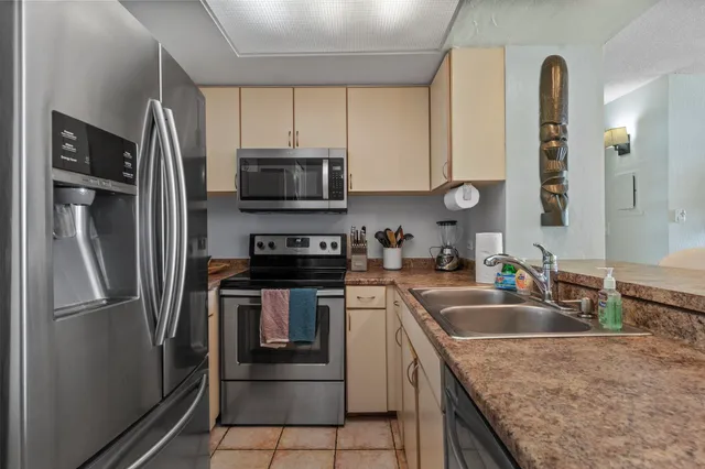a kitchen with granite countertop a refrigerator and a sink
