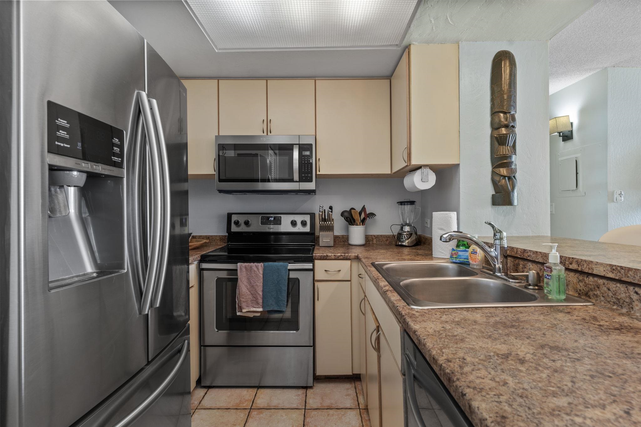 4401 Lower Honoapiilani Road, Unit A101 Lahaina, HI 96761 - Photo 3 of 37 a kitchen with granite countertop a refrigerator and a sink